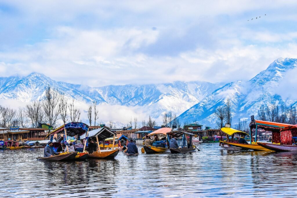 Scenic view of shikara boats on Dal Lake with snow-capped mountains in Srinagar.
